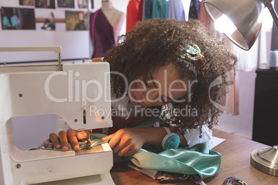 Female fashion designer working with sewing machine