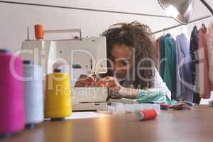 Female fashion designer working with sewing machine