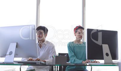 Business people working on computer at desk in office