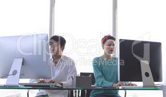 Business people working on computer at desk in office