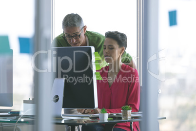 Attentive business people working at desk in creative office