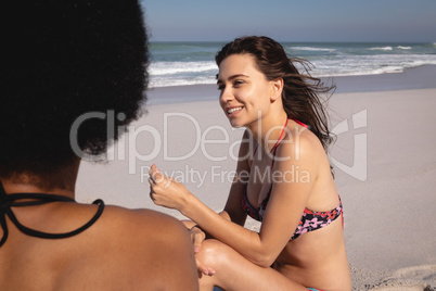 Young women interacting with each other on the beach
