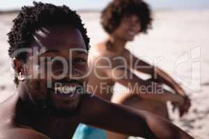 Happy young African American man looking at camera at beach