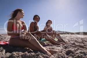 Happy beautiful young women relaxing on beach in the sunshine