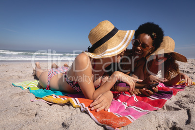 Happy beautiful young women lying and relaxing at beach in the sunshine