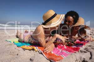 Happy beautiful young women lying and relaxing at beach in the sunshine