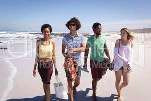 Group of friends walking on the beach in the sunshine