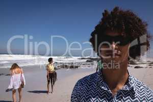 Young man looking at camera on beach in the sunshine