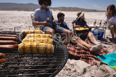 Corn and sausage on barbecue at beach in the sunshine