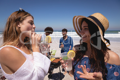 Beautiful young woman drinking cocktail glasses at beach in the sunshine