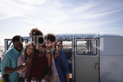 Group of friends taking a selfie while having beer at beach