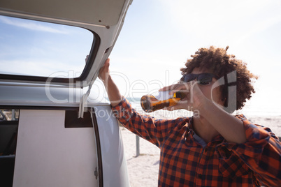 Front view of a man drinking a beer at beach