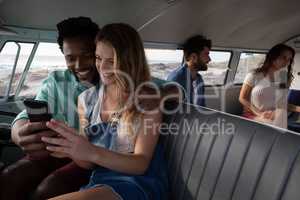 Group of friends interacting with each others in camper van at beach