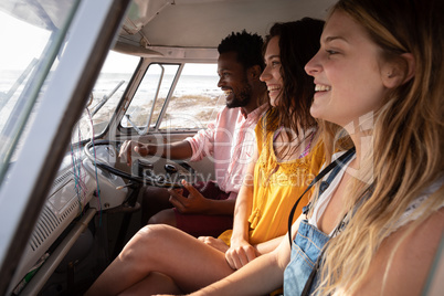 Group of friends enjoying in camper van at beach