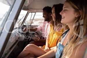 Group of friends enjoying in camper van at beach