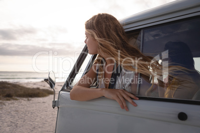 Side view of a Caucasian woman in a camper van with his head outside