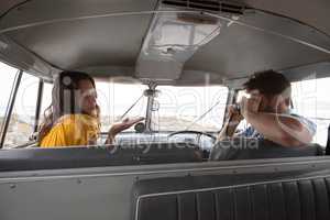 Man taking photo of a woman with digital camera in camper van