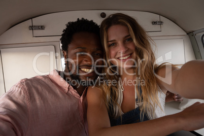 Happy couple sitting in camper van