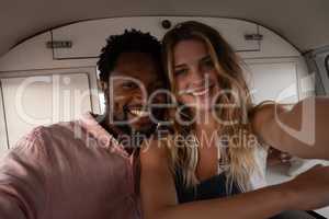 Happy couple sitting in camper van