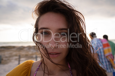 Close-up of a beautiful woman standing at beach on a sunny day