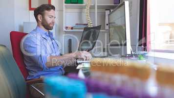 Male doctor checking  x ray report in computer at clinic