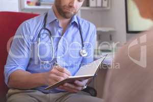 Male doctor and senior woman interacting with each other in clinic