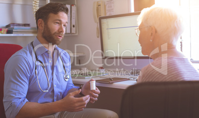 Male doctor and senior woman interacting with each other in clinic