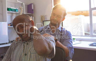 Caucasian male doctor checking neck of a senior man in clinic