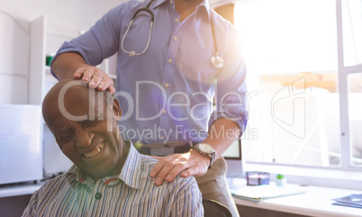 Male doctor doing check up of senior man in clinic