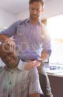 Male doctor doing check up of senior man in clinic