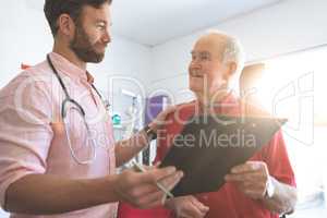 Male doctor showing medical report to senior patient