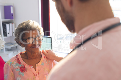 Confident male doctor interacting with female senior patient