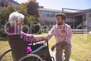 Male doctor talking with disabled senior patient women in wheelchair