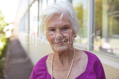 Happy senior woman smiling while standing at nursing park