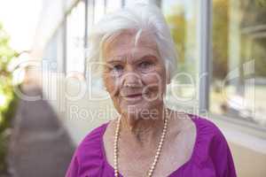 Happy senior woman smiling while standing at nursing park