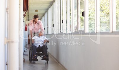 Male doctor pushing senior wheelchair man