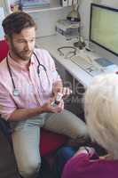 Male doctor prescribing pills to his senior female patient in clinic