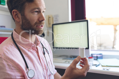 Male doctor prescribing pills to his patient in clinic room