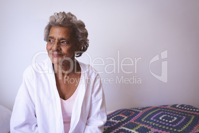 Senior woman smiling while looking outside the window