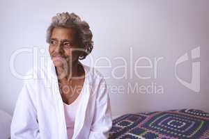 Senior woman smiling while looking outside the window