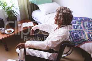 Thoughtful senior woman sitting on wheelchair at nursing home