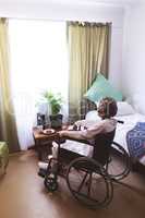Thoughtful senior woman sitting on wheelchair at nursing home