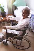 Happy senior woman sitting in wheelchair at nursing home