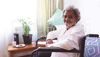 Happy senior woman sitting in wheelchair at nursing home