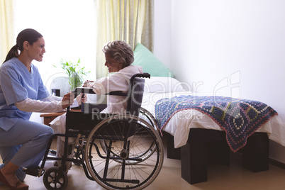 Nurse talking with senior female patient at nursing home