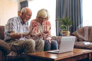 Senior couple making video call on laptop at retirement home