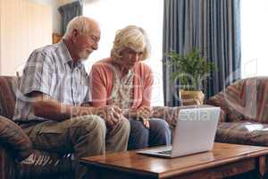 Senior couple making video call on laptop at retirement home