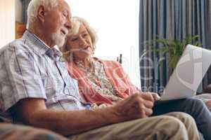 Couple interacting with each other while using laptop