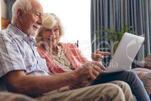 Couple interacting with each other while using laptop