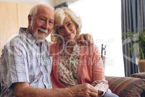 Senior couple sitting on sofa at retirement home